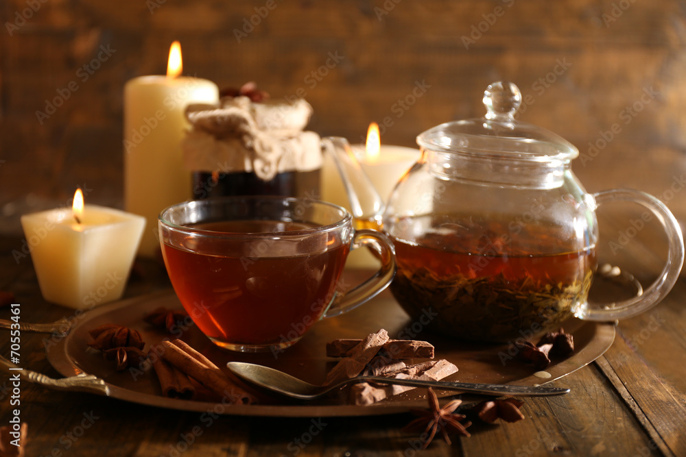 Composition with tea in cup and teapot and candles
