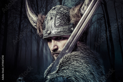 Fotografie, Obraz Sword, Viking warrior with helmet over forest background