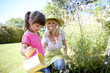 © goodluz - Woman with little girl watering plants in garden