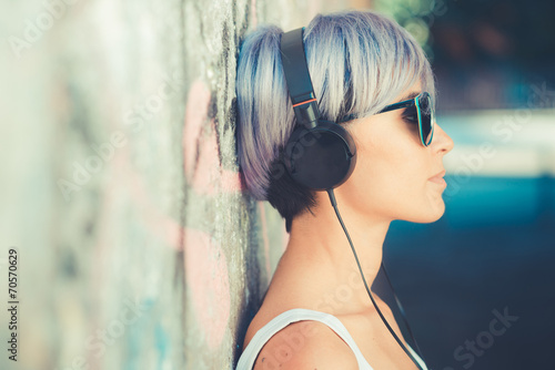 Tapeta ścienna Młode piękne krótkie niebieskie włosy hipster kobieta ze słuchawkami mu
