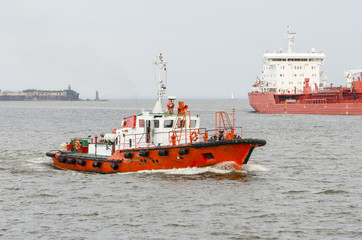 A pilot boat and a large cargo ship