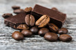 close up of coffee beans and  chocolate on gray background