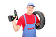 © Ljupco Smokovski - Male mechanic holding a tire and a drill