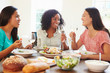 © Monkey Business - Group Of Female Friends Enjoying Meal At Home