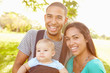 © Monkey Business - Family With Baby Son In Carrier Walking Through Park