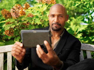 mature african man using tablet outdoors