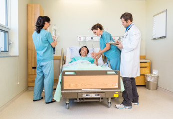 Wall Mural - Nurses And Doctor Examining Patient In Hospital