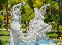 Sculpture Of Half-naked Sea Siren And Mermaid  In Garden