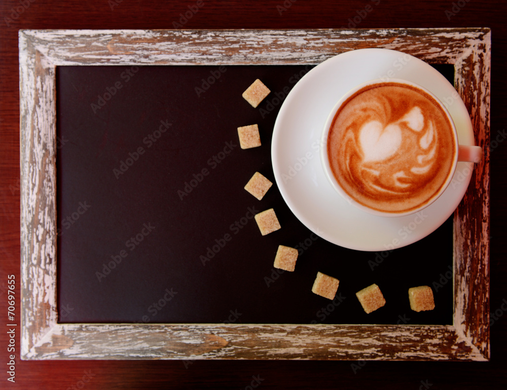 Cup of coffee with cute drawing in cafe