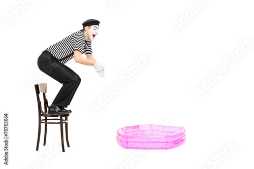 Fotografie, Obraz Mime artist jumping into a small inflatable pool i