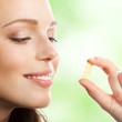 © vgstudio - Woman with Omega 3 fish oil capsule, outdoor