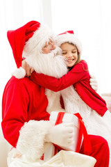 Poster - smiling girl with santa claus and gift at home