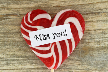 Wall Mural - miss you card with heart shaped lollipop on wooden surface