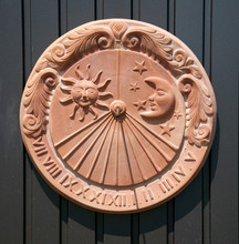 Sundial Made Of Clay Hanging On A Metal Door