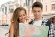 © zinkevych - Beautiful couple of tourists holding a map in their hands, conce