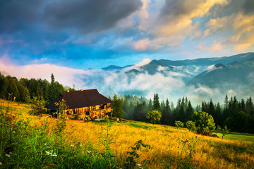 Wall Mural - amazing mountain landscape with fog and a haystack