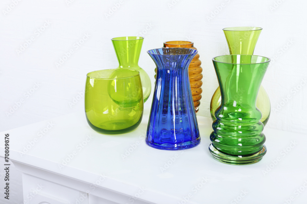 Colorful vases on white table, close-up