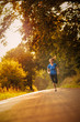Sportliche Frau läuft am Morgen auf einer ländlichen Straße