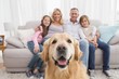 © WavebreakmediaMicro - Family sitting on the couch with golden retriever in foreground