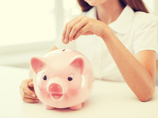 Canvas Print - smiling child putting coin into big piggy bank