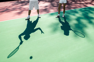 Players shadows on the tennis court