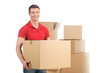 © BlueSkyImages - man holding moving box and smiling at camera.