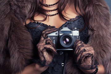 Wall Mural - woman wearing corset and fur and holding vintage camera