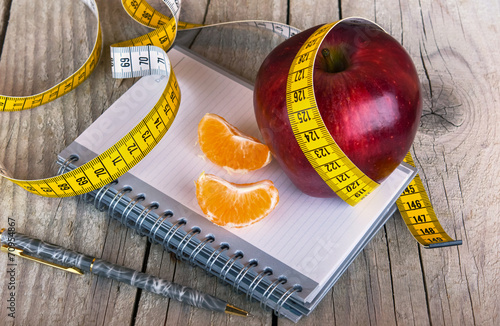 Fotografia Measuring tape wrapped around a apple weight loss photo