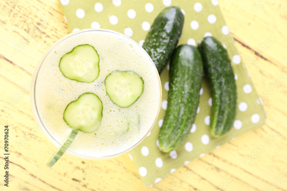 Cucumber cocktail on polka dot napkin on wooden background