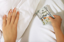Woman Hiding Money Under Pillow At Home