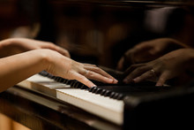 Woman's Hands On The Keyboard Of The Piano Closeup