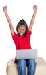 © akulamatiau - Young Asian girl with a laptop raising her arms