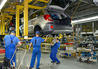 Wall Mural - Workers on the assembly conveyor of automobile plant