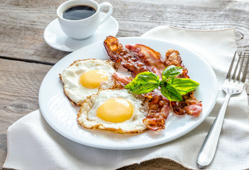 Poster - Fried eggs with bacon on the wooden table