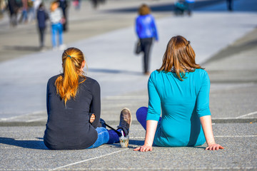 Two girls chilling out on the ground