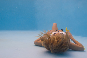 Wall Mural - Young woman swimming underwater