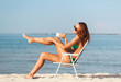 © Syda Productions - smiling young woman sunbathing in lounge on beach