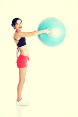 Wall Mural - Beautiful young woman with pilates exercise ball.