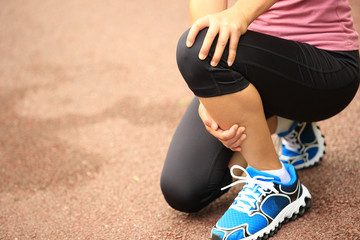 Canvas Print -  woman runner hold her sports injured knee 