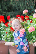 © vitmark - Adorable little child girl in park near flower Bed in summer