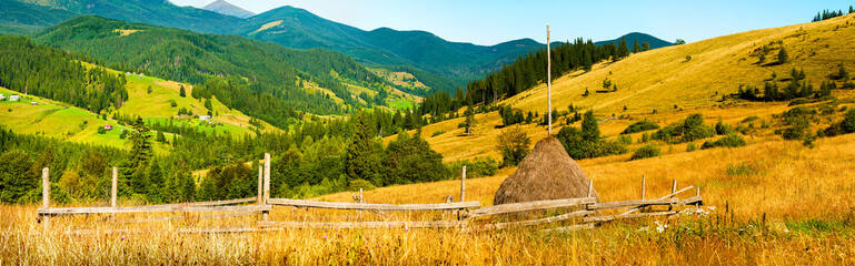 Wall Mural - amazing mountain landscape with fog and a haystack