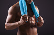 © cristovao31 - Athletic man holding a blue towel on black background