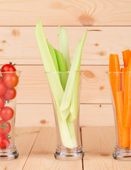 Sticker - Glasses full of sliced vegetables on wood table.