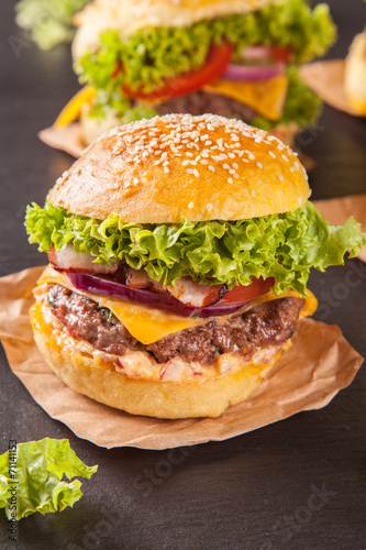 Naklejka samoprzylepna Świeże hamburgery podawane na czarnym kamieniu