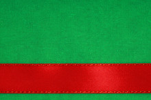 Red Ribbon On Green Fabric Background With Copy Space.