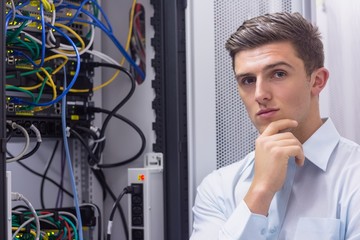 Poster - Thoughtful young technician with arms crossed