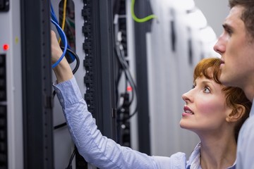 Poster - Team of technicians talking and looking at server