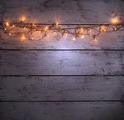 Wall Mural - Christmas lights on wooden background