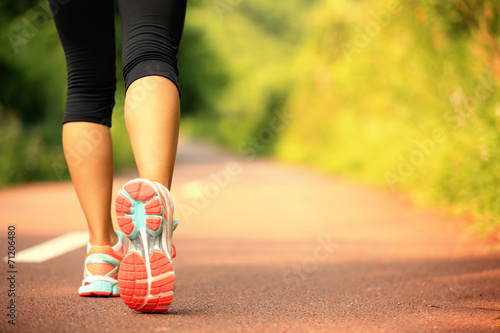 Fotografía young fitness woman legs walking on forest trail