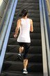 © lzf - Runner athlete running on escalator stairs.